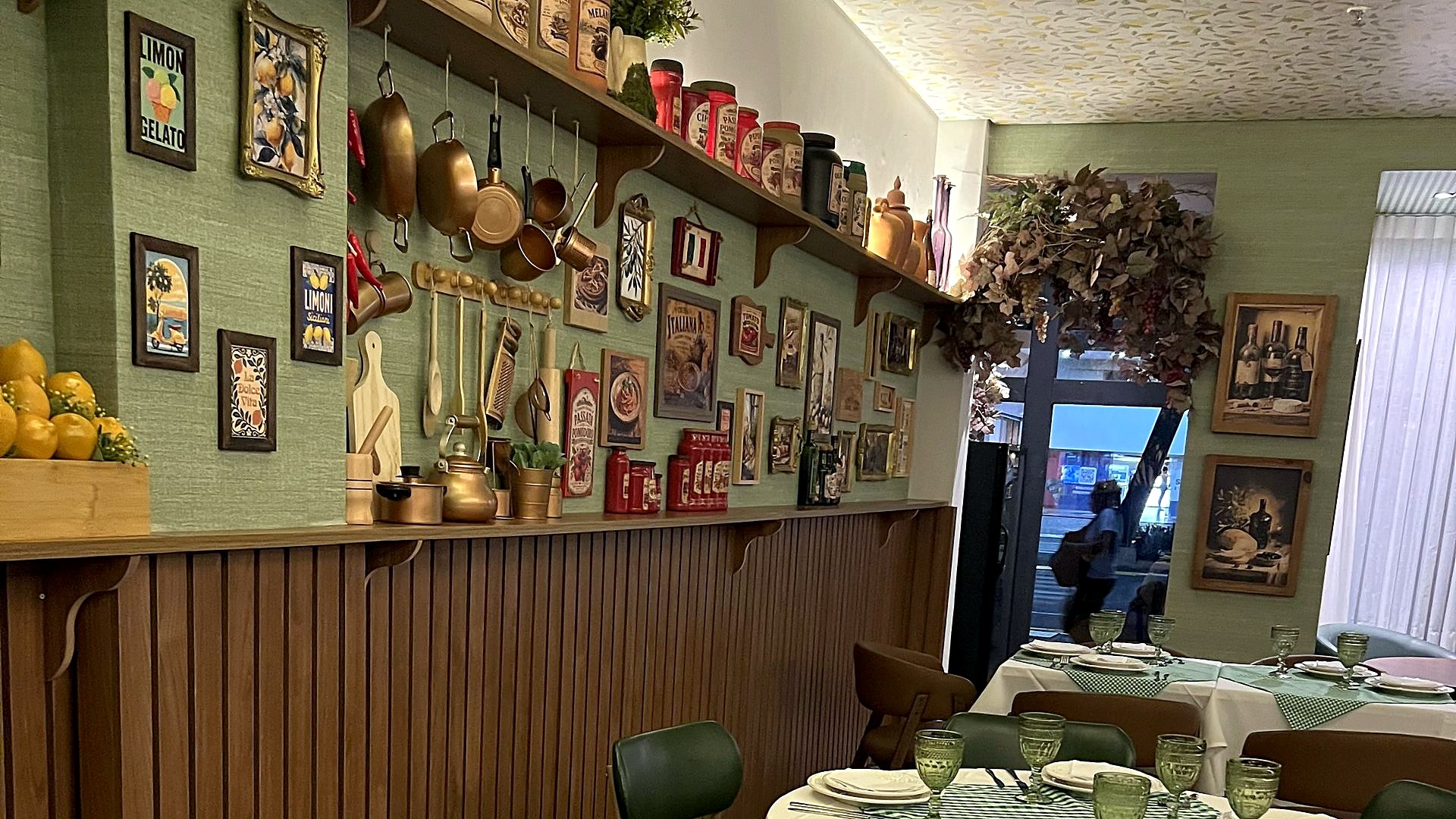 A prateleira da cozinha do Forneatto: panelas de cobre, potes de conserva e os cartazes italianos