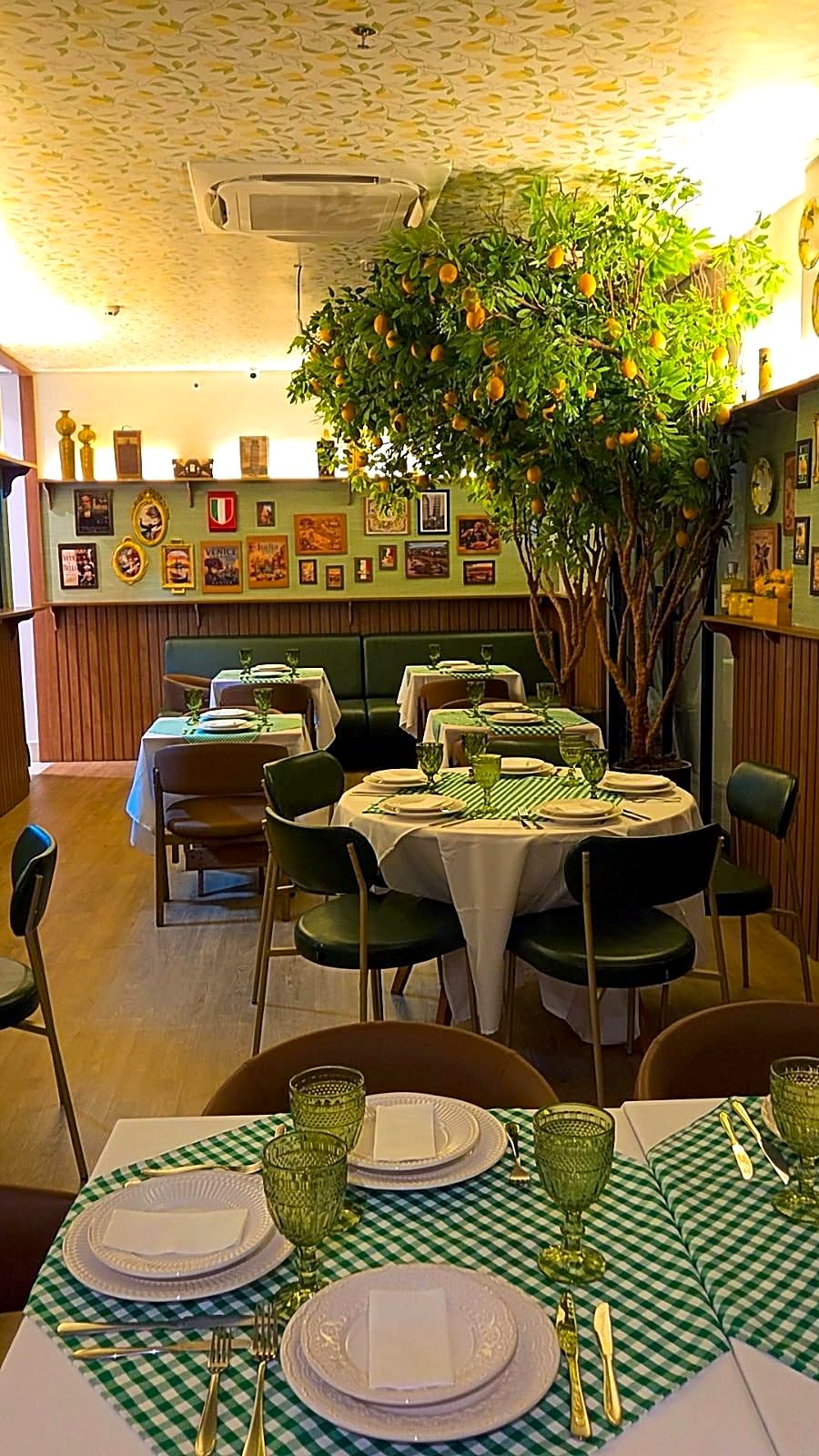 Mesa posta do Forneatto: pratos, taças verdes e toalha xadrez